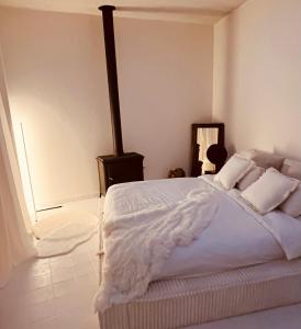 une chambre avec un grand lit avec des draps et des oreillers blancs dans l'établissement CasaMia Lofts, à Anvers