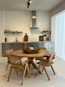 une cuisine avec une table en bois et quelques chaises dans l'établissement CasaMia Lofts, à Anvers
