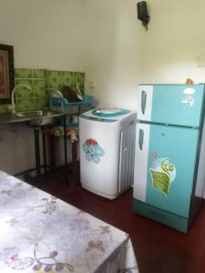 a kitchen with a refrigerator and a washing machine at Dune Villa in Hikkaduwa