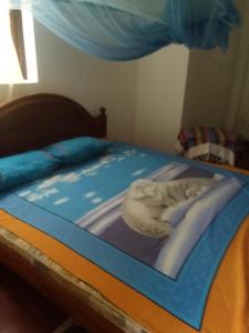 a bed with a blue and white blanket on it at Dune Villa in Hikkaduwa