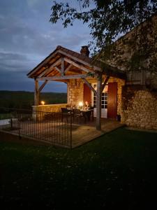 ein Holzpavillon mit einem Tisch vor einem Gebäude in der Unterkunft Domaine de Cazal - Gîte 2 pers avec piscine au cœur de 26 hectares de nature préservée in Saint-Cyprien