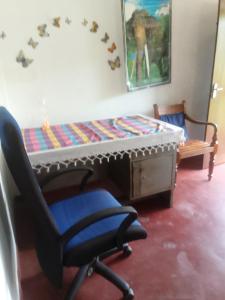 a room with a chair and a bed and a table at Dune Villa in Hikkaduwa