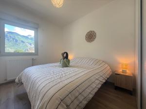 a teddy bear sitting on a bed in a bedroom at Le Moulin Balcon Proche Centre Calme in Saint-Jean-de-Maurienne
