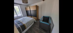una piccola camera da letto con un letto e una finestra di De l'herbe jusqu'aux genoux - appartement 60 m2 a La Vancelle
