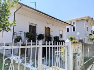 a white fence in front of a white house at Da zia Concetta, casa vacanze immersa nel verde in Colledara