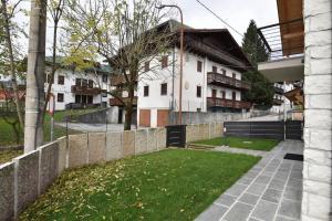 a fence in front of a house with a yard at Chalet Emy in Gallio