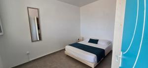 a bedroom with a bed and a mirror on the wall at La Fleur Doré F3 Le Vauclin in Le Vauclin