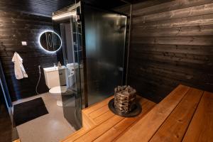 a bathroom with a toilet in a room with wooden walls at Villa Jokiranta in Lapland in Ranua