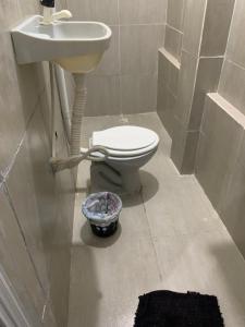 łazienka z toaletą i umywalką w obiekcie Kitnet Dream House w mieście Bayeux