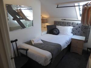 a small bedroom with a bed with a mirror at Falstaff Cottage, NEW HOT TUB, Sleeps up to 5, Stratford upon Avon in Stratford-upon-Avon +48 photos