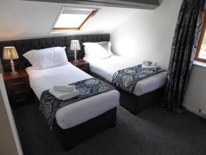 a hotel room with two beds and a window at Falstaff Cottage, NEW HOT TUB, Sleeps up to 5, Stratford upon Avon in Stratford-upon-Avon