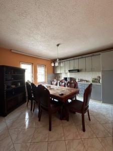 a kitchen with a dining room table and chairs at Charming Ferizaj Villa in Ferizaj