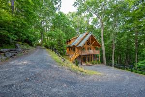 a log cabin in the woods with a driveway at Rock n Rhapsody - Blue Ridge Log Cabin - Minutes to West Jefferson - Fireplace - Foosball in West Jefferson