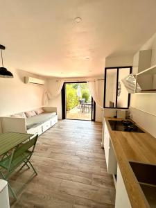 a kitchen and living room with a bed and a table at Les Marines, Castello Rosso vue mer - Accès plage à pied in Casaglione +12 photos