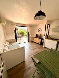 a room with a bed and a table and a kitchen at Les Marines, Castello Rosso vue mer - Accès plage à pied in Casaglione