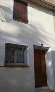 ein weißes Gebäude mit einem Fenster und einer Tür in der Unterkunft Le Gite des Remparts in Ginestas