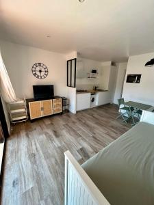 a living room with a bed and a clock on the wall at Les Marines, Castello Rosso vue mer - Accès plage à pied in Casaglione