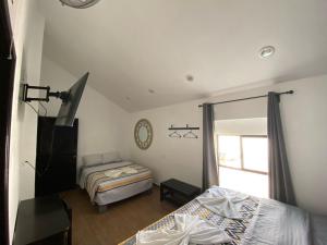 a bedroom with two beds and a window at Hotel Santo Domingo in Comitán +2 photos