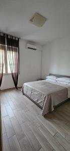 Un dormitorio con una cama grande y una ventana. en Cagliariparadiseapartments it Cicala, en Cagliari