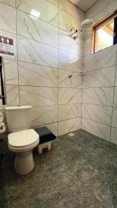 ein Badezimmer mit weißer Toilette und Dusche in der Unterkunft Sitio Silveira Nobre - São Joaquim de Bicas in São Joaquim de Bicas