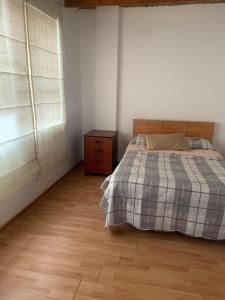 a bedroom with a bed and a wooden floor at Casa Ruiz Ganoza in San Antonio