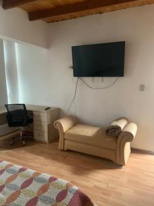 a living room with a couch and a flat screen tv at Casa Ruiz Ganoza in San Antonio