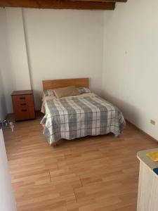 a bedroom with a bed and a wooden floor at Casa Ruiz Ganoza in San Antonio +1 photo