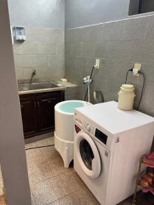 a washing machine in a bathroom with a sink at Mariano in Encarnación