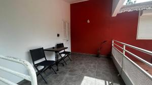 a room with a table and chairs and a red wall at Appart équipé tout confort in Le François