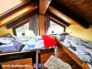a bedroom with two beds and a window at BAITA LOVELY AND CENTRAL SAUZE D'OULX in Sauze dʼOulx
