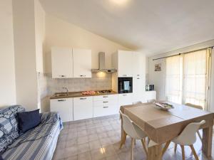 a kitchen and dining room with a table and a couch at Residenza Centrale in Villasimius