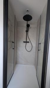 a shower with a glass door with a shower head at Résidence Tamaris Paloma in Plouër-sur-Rance +24 photos