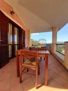 a wooden table and chair on a balcony at Casa Bella Vista in Villasimius
