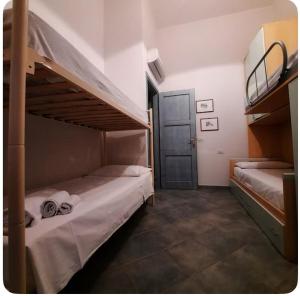 a bedroom with two bunk beds and a door at Casa Bella Vista in Villasimius