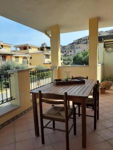a wooden table and chairs on a balcony at Casa Bella Vista in Villasimius