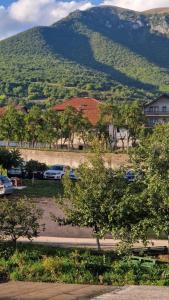 a parking lot with cars parked in front of a mountain at Apartman Katja Travnik in Travnik