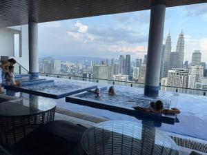 a group of people swimming in a pool on a building at The Luxe Colony KLCC by Rsafa in Kuala Lumpur