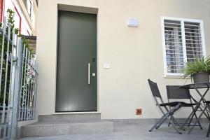 a black door on a house with two chairs at La Casina di Luca in Rimini