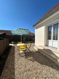 eine Terrasse mit Tisch und Sonnenschirm in der Unterkunft Maison calme avec jardin & terrasses 