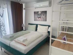 Dormitorio pequeño con cama y estante de libros en Baynunah Suites Aparthotel, en Múnich