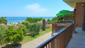 a balcony of a house with a green umbrella at b&b Villa Eugenia in Campofilone