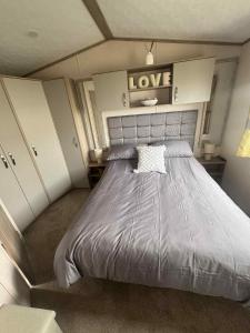 a bedroom with a large bed with a love sign above it at 149 Northfield in Ulrome