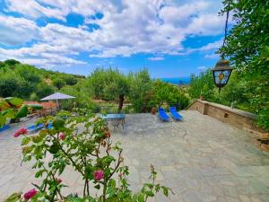 a patio with blue chairs and a view of the ocean at Villa Elena - Renovated Gem with Stunning Sea Views in Neos Marmaras