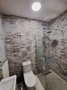 a bathroom with a toilet and a glass shower at Villa Elena - Renovated Gem with Stunning Sea Views in Neos Marmaras