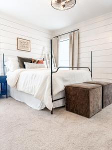 une chambre avec un grand lit avec un pouf en bois dans l'établissement Heritage House, à Brady