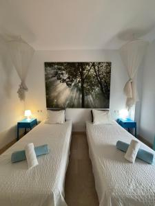 zwei Betten in einem Zimmer mit einem Gemälde an der Wand in der Unterkunft Delicate child friendly ground floor apartment in Mijas Costa
