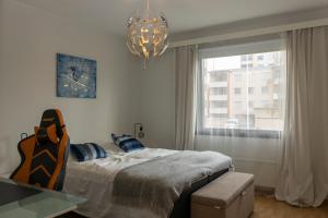 a bedroom with a bed and a window and a chandelier at One-bedroom apartment with free parking in Oulu