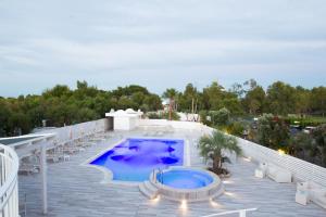 an outdoor swimming pool on a patio with chairs and a swimming pool at Garden Hotel Ripa in Vieste