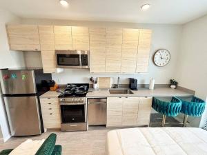 a kitchen with stainless steel appliances and a clock on the wall at Tranquil Escape in Des Moines