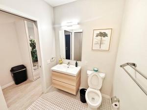 a white bathroom with a toilet and a sink at Tranquil Escape in Des Moines +19 photos